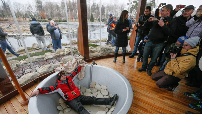 Một người biểu tình chụp hình cùng với một bể tắm trong dinh thự của ông Yanukovych. Ảnh: EPA