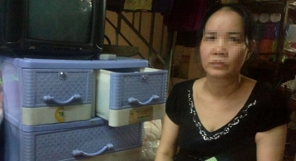 Ảnh: Bà Nguyễn Thị Loan thẫn thờ bên cuốn sổ cho vay giờ đã trở thành giấy lộn