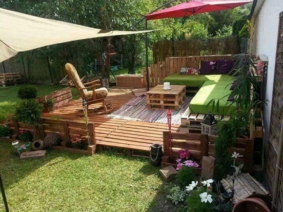 Bục gỗ với nội thất phong cách từ pallet, và tán cây.