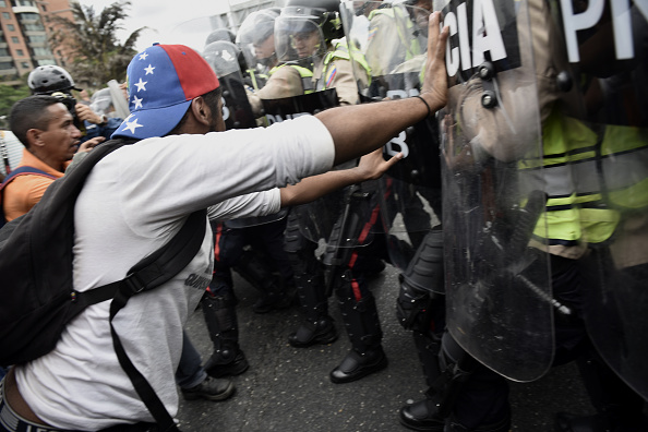 Đụng độ xảy ra giữa người biểu tình và cảnh sát chống bạo động Venezuela. Ở thời điểm hiện tại, người dân quốc gia Nam Mỹ đang phải sống trong cảnh thiếu thốn tới cùng cực. Điện và nước cũng thường xuyên bị cắt. Ảnh: Getty