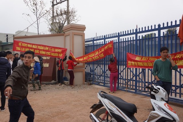 Người dân căng băng rôn, khẩu hiệu trước cổng nhà máy thể hiện sự bức xúc. Ảnh: Nguyễn Dương.
