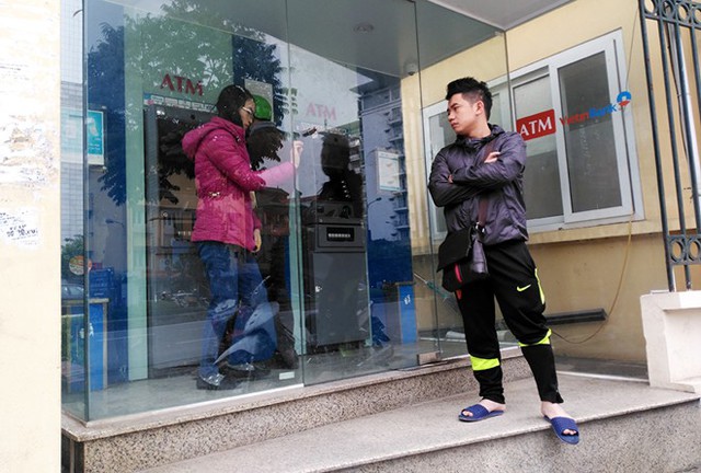 Một trong hai cây ATM báo hỏng, người dân ngao ngán xếp hàng chờ đợi - Ảnh: Minh Tú