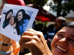 Người dân Venezuela vui mừng cầm bức ảnh Tổng thống Chavez và hai con gái. (Nguồn: Reuters)