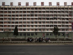 Người dân đi ngang qua một tòa nhà ở trung tâm thủ đô Bình Nhưỡng (Triều Tiên) - Ảnh: Reuters 