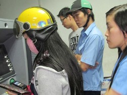 Nhiều công nhân xếp hàng chờ rút tiền bên máy ATM ở KCX Tân Thuận, TP.HCM tối 30-1. Ảnh: Ánh Hồng .