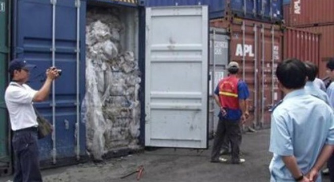 Cơ quan chức năng kiểm tra một container chứa rác thải công nghiệp. (Ảnh: Báo Tin tức) 