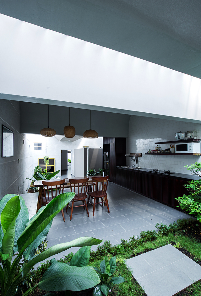 Khu vực nhà bếp nằm song song với phòng khách. Khoảng đất nhỏ trồng cây xanh là không gian ngăn cách giữa hai khu vực.